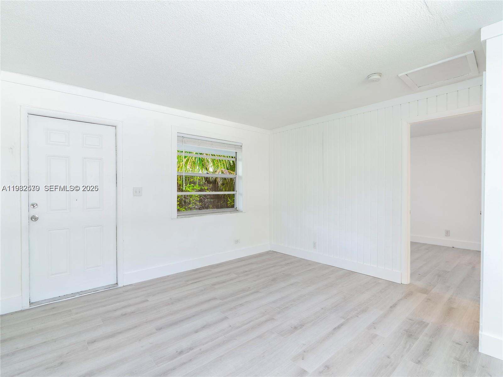 2020 Miami Road, Unit B Fort Lauderdale, FL 33316 - Photo 3 of 9 an empty room with wooden floor and windows