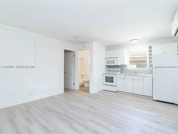 a view of a kitchen with white cabinets and stainless steel appliances