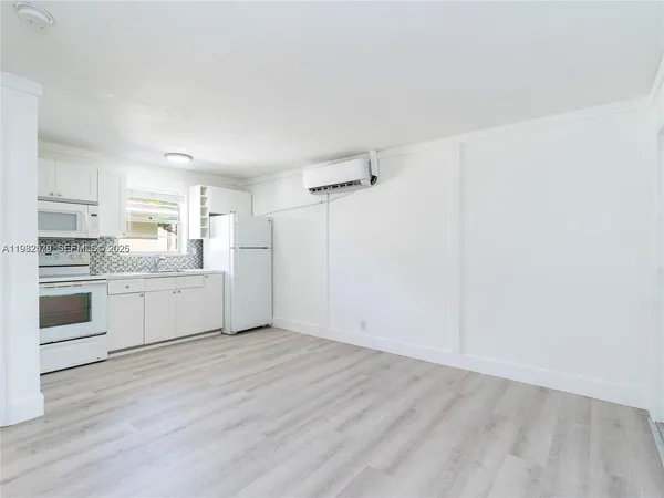 a kitchen with white cabinets and white appliances