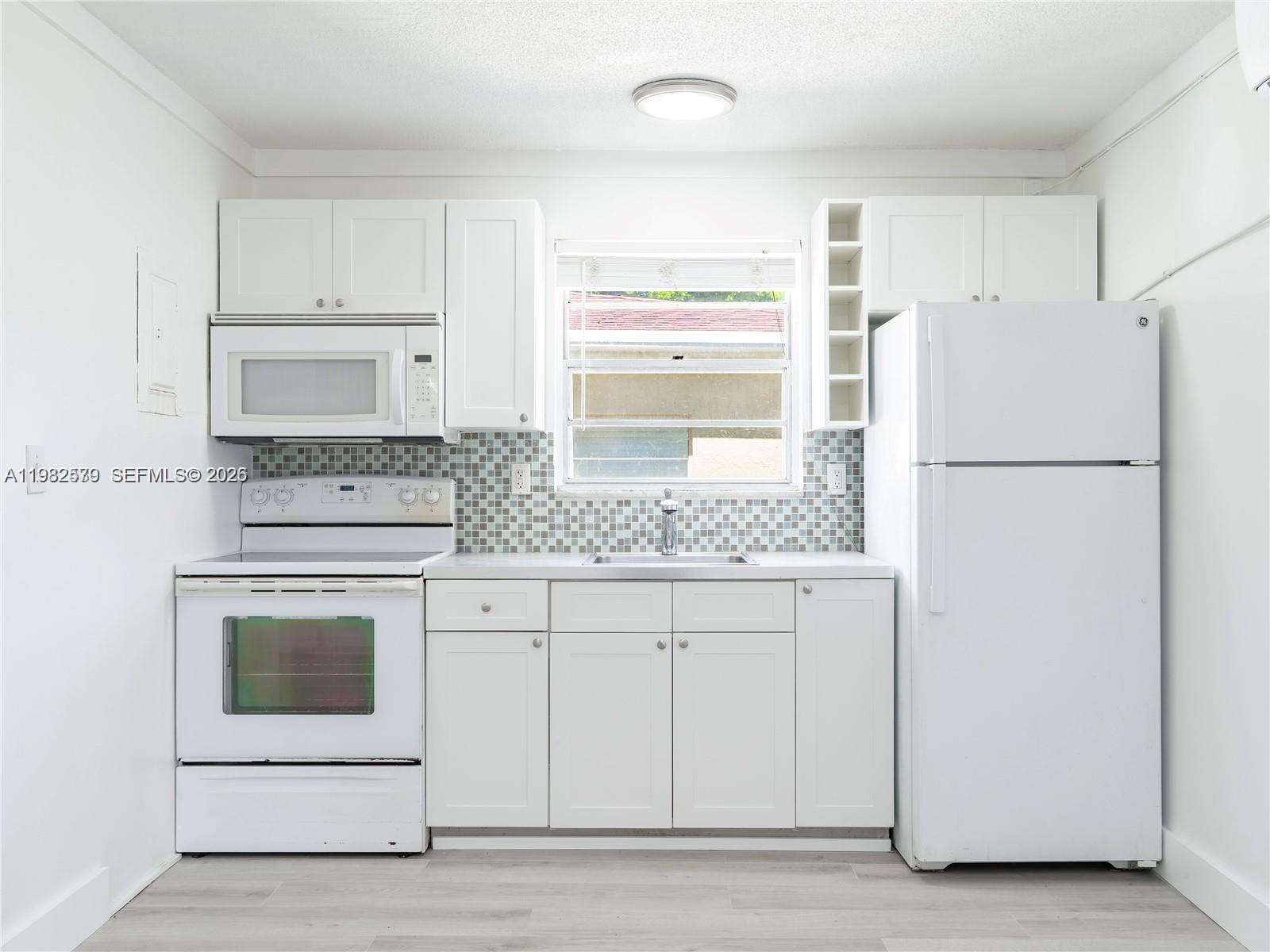 2020 Miami Road, Unit B Fort Lauderdale, FL 33316 - Photo 6 of 9 a kitchen with white cabinets and white appliances