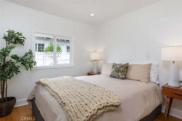 a bedroom with a bed and a potted plant