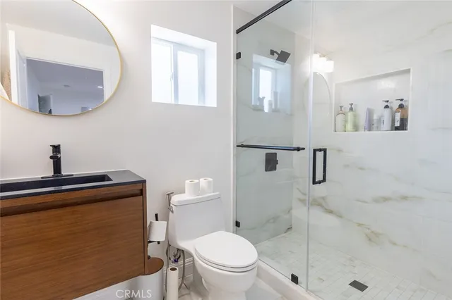 a bathroom with a toilet a sink and mirror