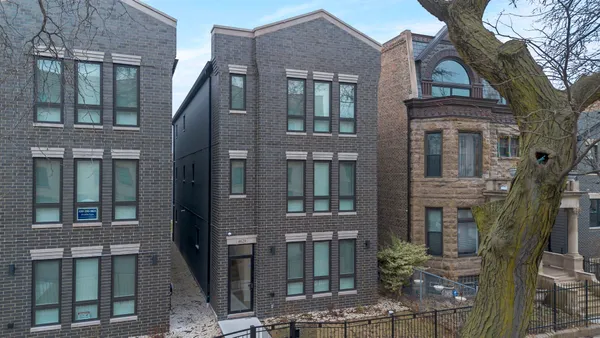 a front view of a residential apartment building with a yard