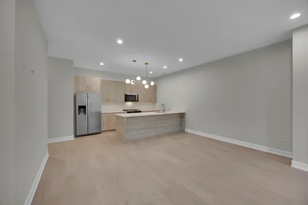 a view of kitchen with kitchen island a sink stainless steel appliances and cabinets