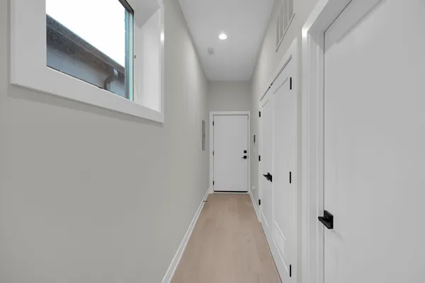 a view of a hallway with wooden floor and staircase