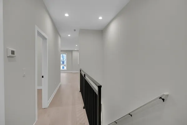 a hallway with wooden floor and staircase