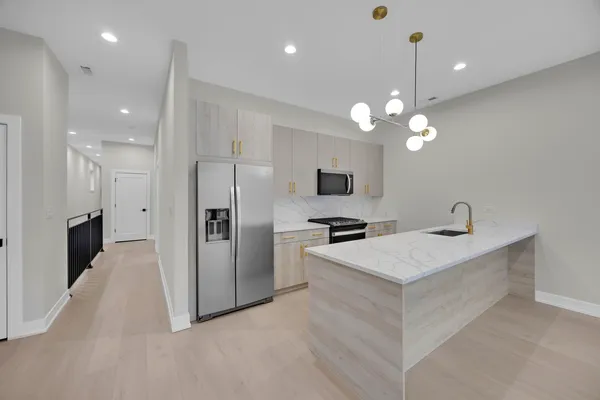 a large white kitchen with a sink dishwasher stove and refrigerator