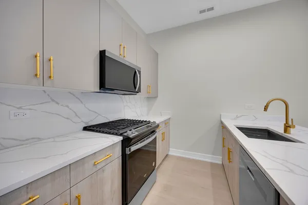 a kitchen with stainless steel appliances granite countertop a sink and a stove top oven with a dishwasher