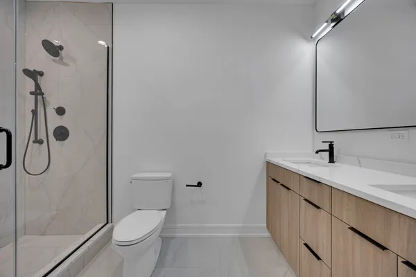 a bathroom with a granite countertop sink a toilet and shower