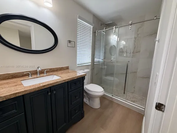 a bathroom with a double vanity sink toilet and a mirror