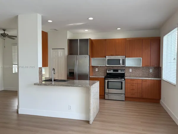 a kitchen with stainless steel appliances granite countertop a stove a sink and a refrigerator