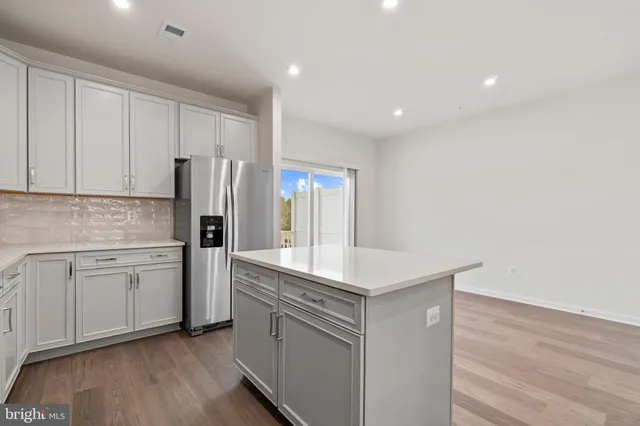 a kitchen with a refrigerator sink and cabinets