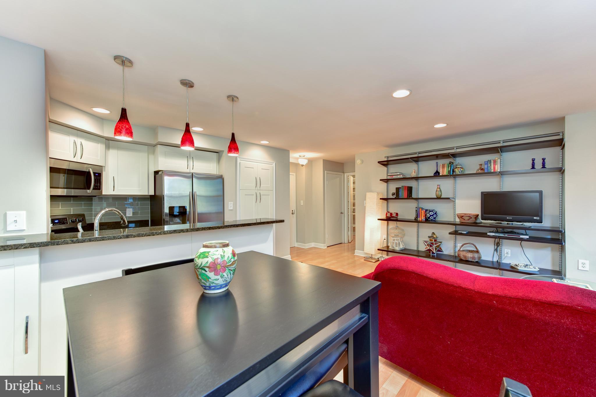 2440 16th Street Northwest, Unit 412 Washington, DC 20009 - Photo 11 of 25 a kitchen with stainless steel appliances granite countertop a sink dishwasher and a flat screen tv
