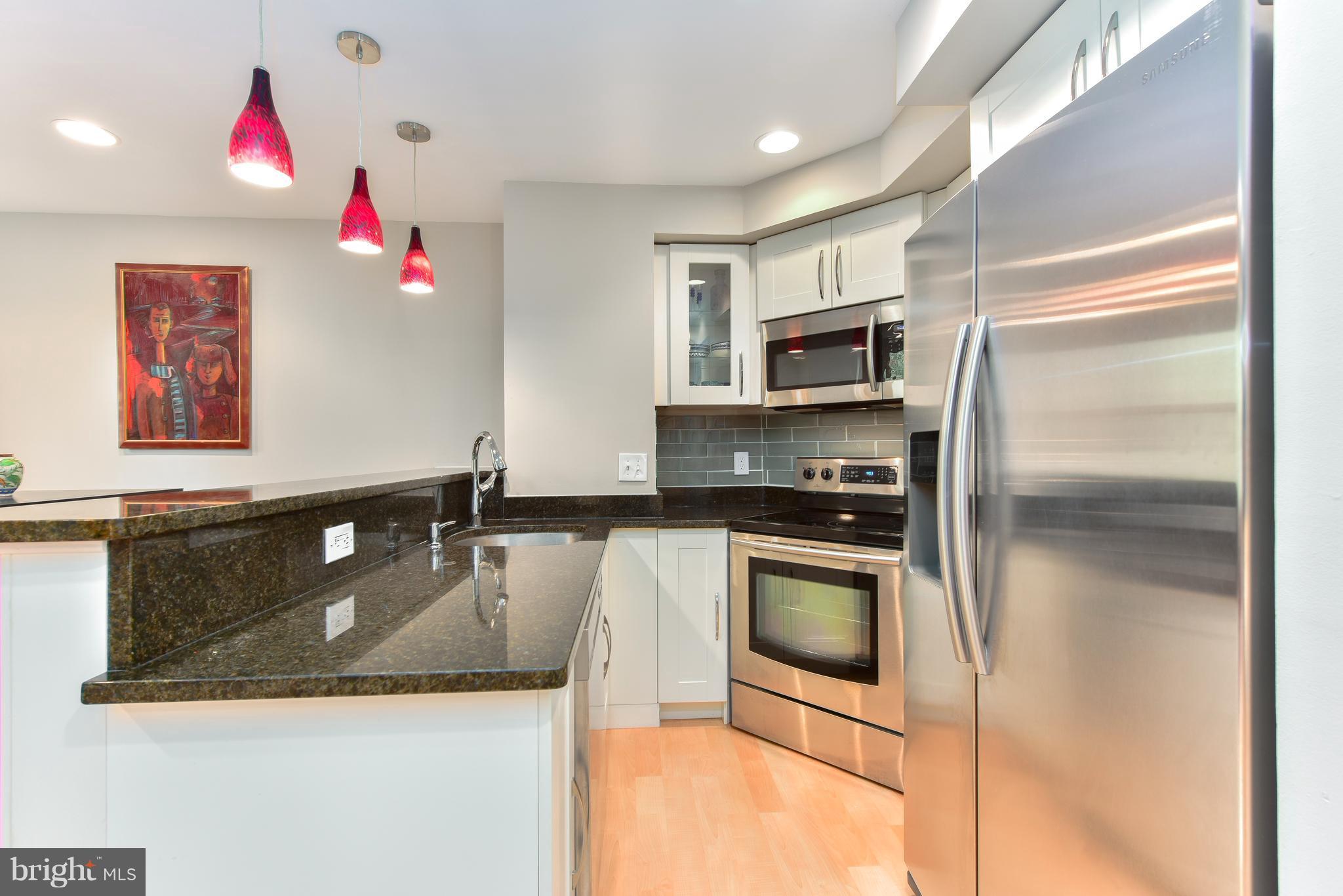2440 16th Street Northwest, Unit 412 Washington, DC 20009 - Photo 13 of 25 a kitchen with granite countertop a sink and stainless steel appliances