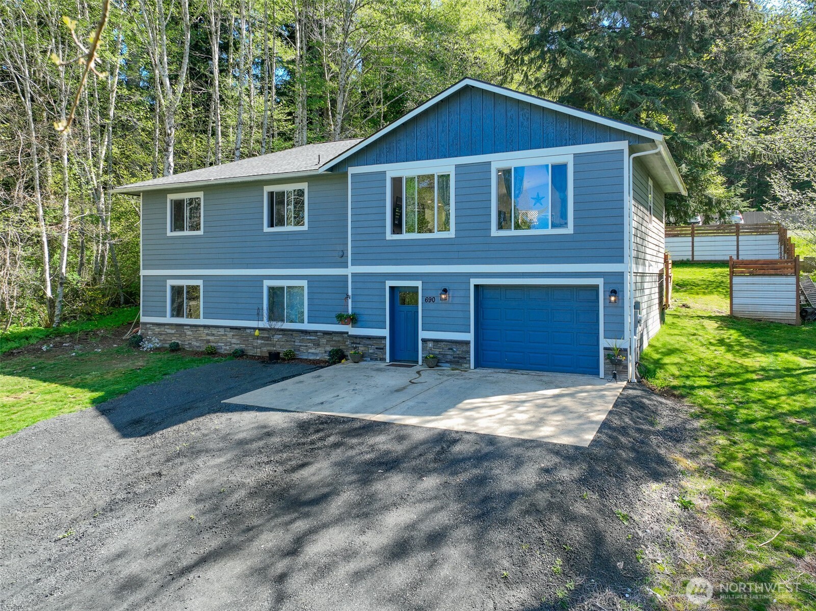 690 North Summit Road McCleary, WA 98557 - Photo 1 of 40 a front view of a house with a yard and garage