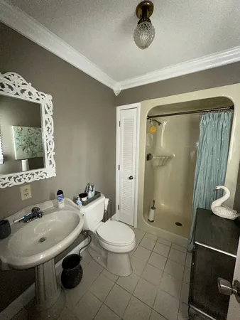a bathroom with a toilet a sink and mirror