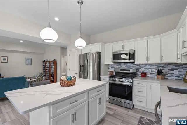 a kitchen with a center island a counter space cabinets and stainless steel appliances