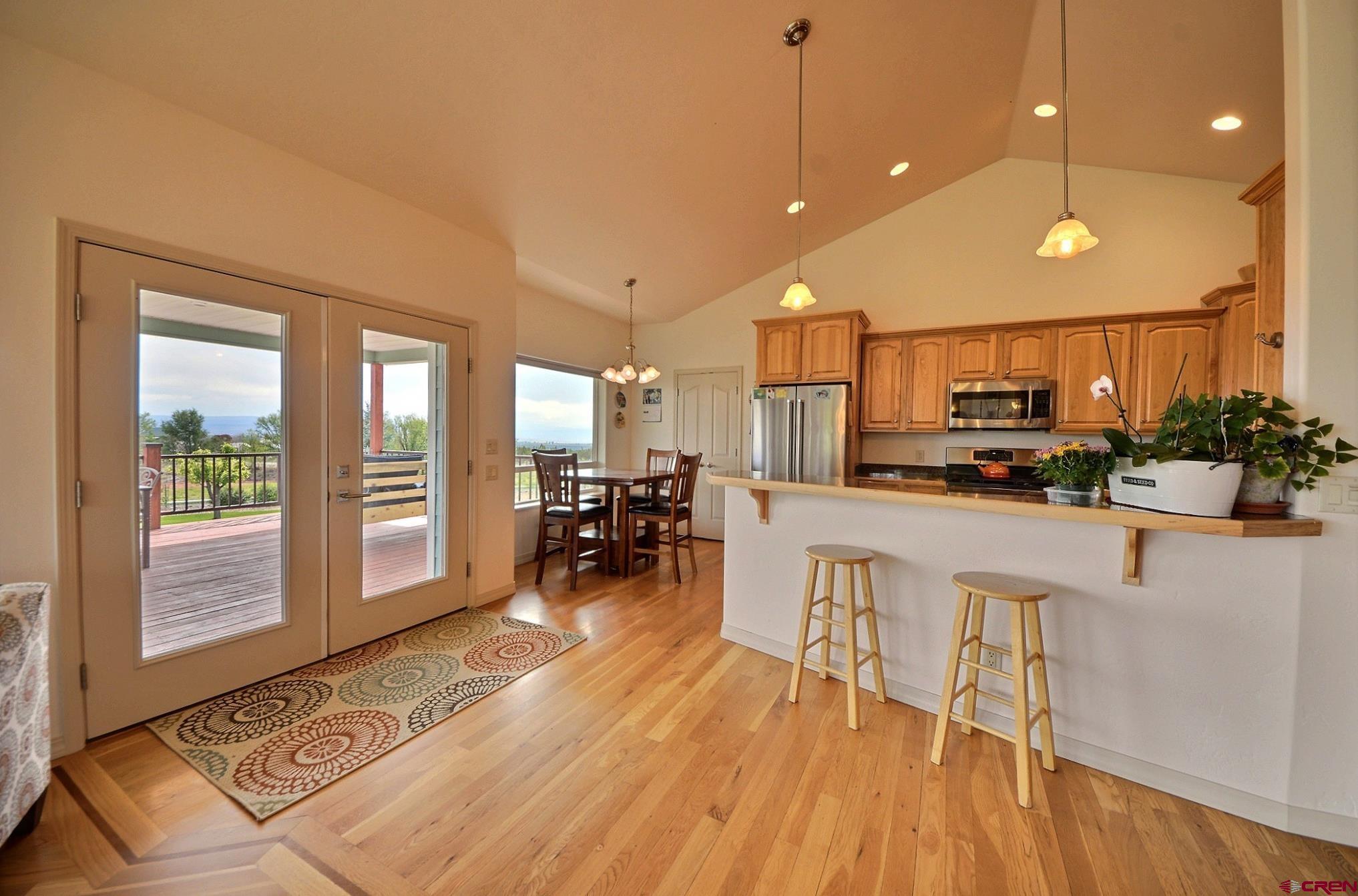 15423 2525th Road Cedaredge, CO 81413 - Photo 7 of 35 a kitchen with stainless steel appliances a dining table chairs stove and white cabinets