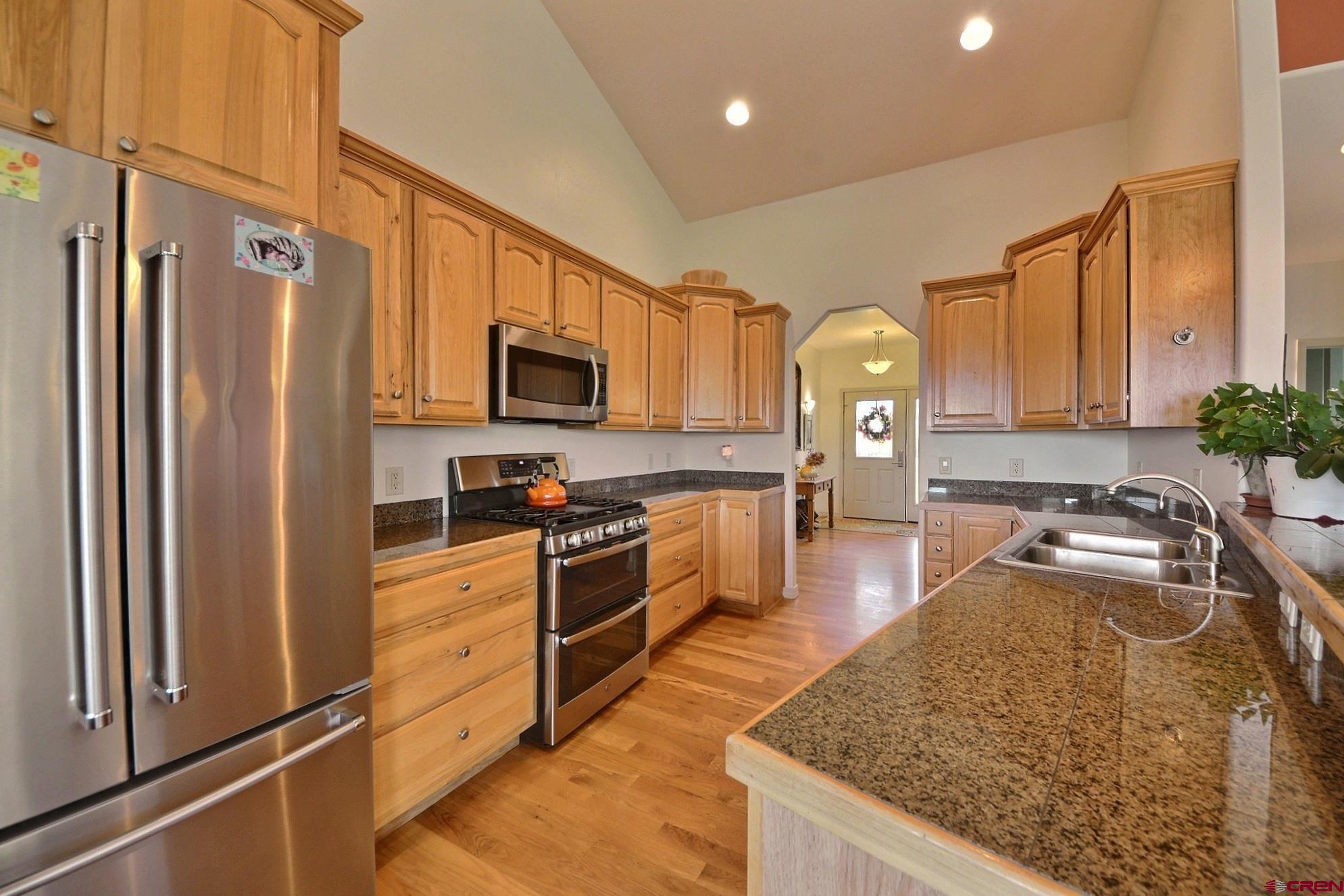 15423 2525th Road Cedaredge, CO 81413 - Photo 9 of 35 a kitchen with granite countertop a refrigerator stove top oven and sink