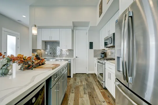 a kitchen with white cabinets and stainless steel appliances