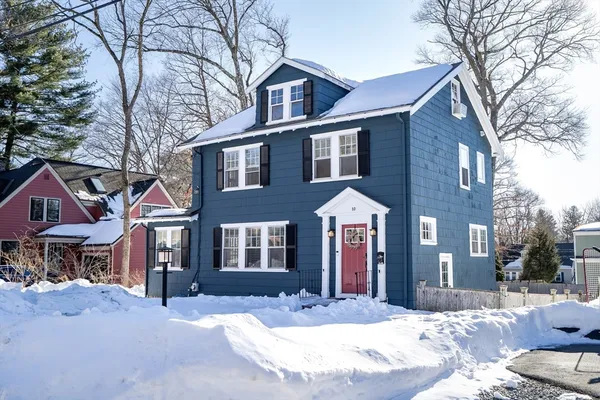 a front view of a house with a yard covered in snow