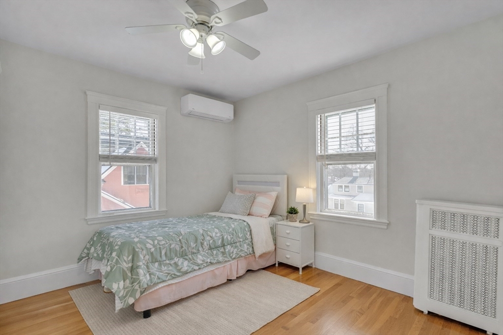 10 Dexter Road Lexington, MA 02420 - Photo 18 of 30 a bedroom with a large bed chandelier and a window