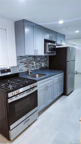 a kitchen with stainless steel appliances granite countertop a stove and a refrigerator
