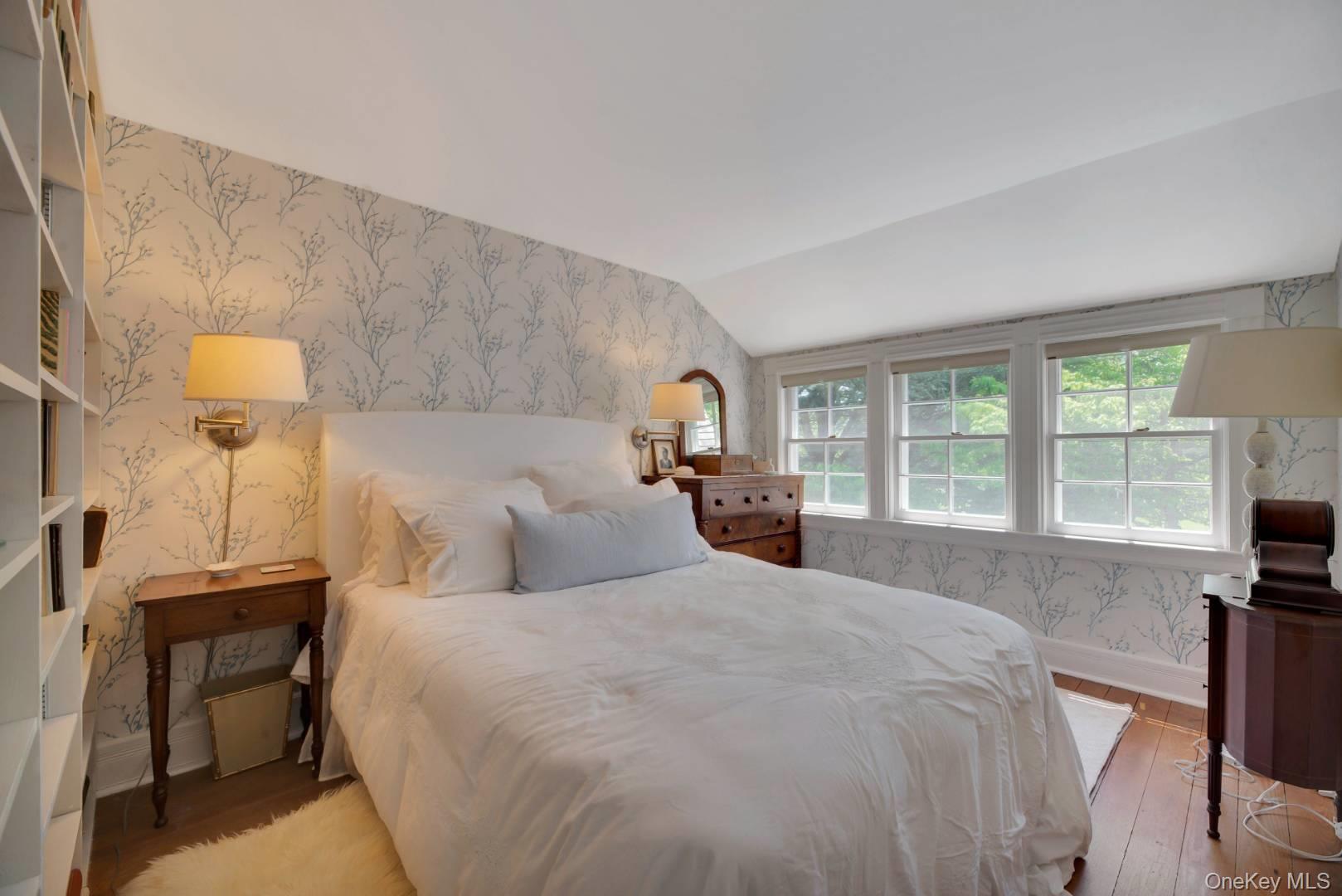 90 Old Depot Road Quogue, NY 11959 - Photo 12 of 21 a large bed sitting in a bedroom next to a window with a lamp on table and a large window
