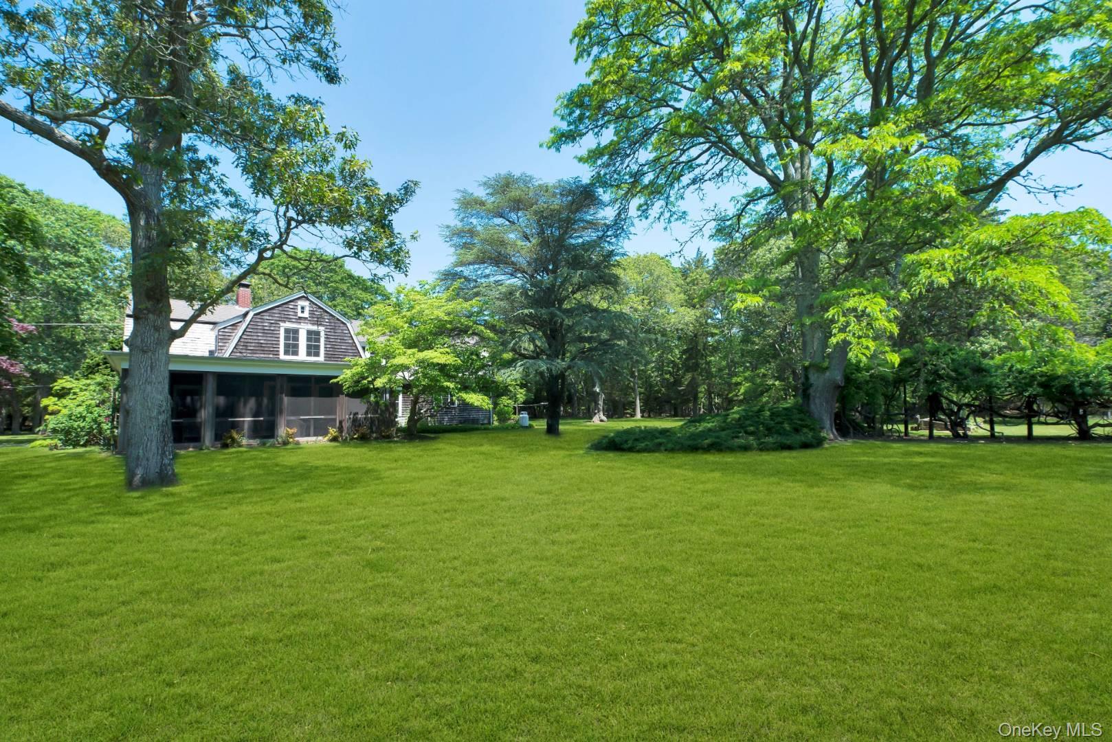 90 Old Depot Road Quogue, NY 11959 - Photo 19 of 21 a house with huge green field in front of it