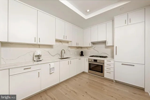 a kitchen with granite countertop white cabinets and white appliances