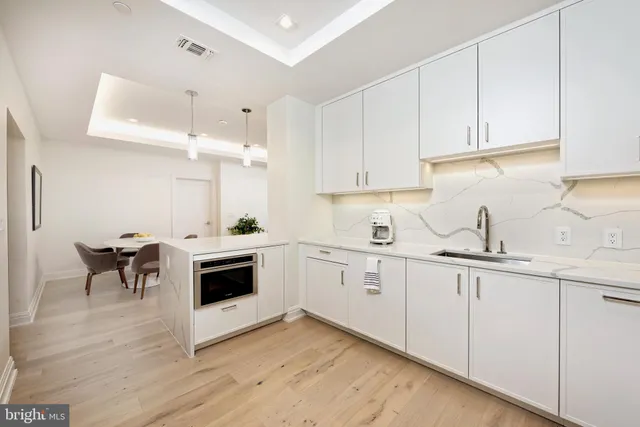 a kitchen with granite countertop white cabinets and white appliances
