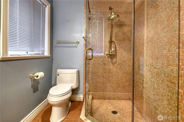 a bathroom with a toilet and a shower