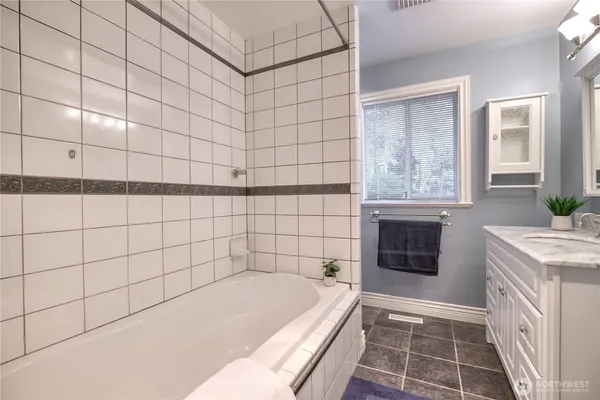 a bathroom with a tub sink and granite