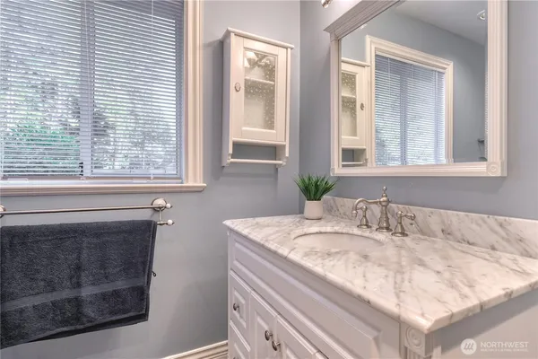 a bathroom with a granite countertop sink and a bathtub