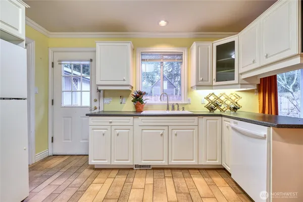 a kitchen with granite countertop white cabinets and window