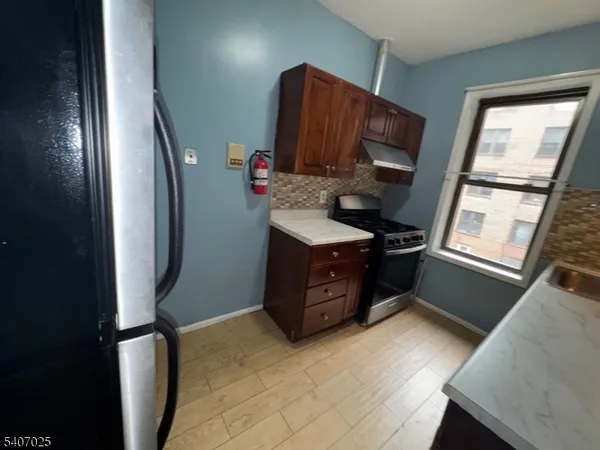 a kitchen with stainless steel appliances granite countertop a refrigerator stove and sink