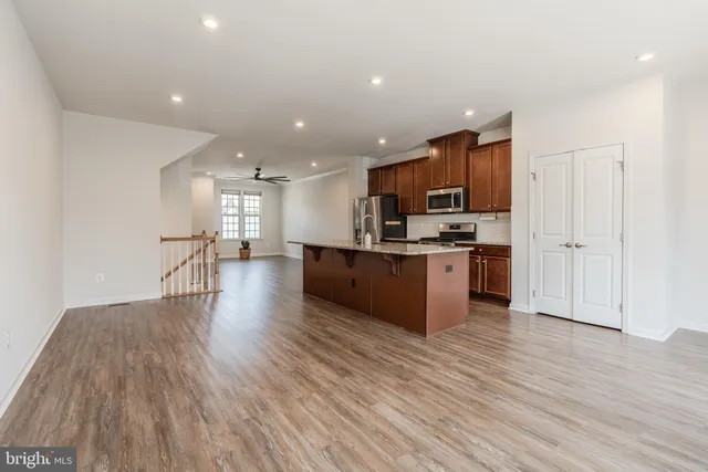 a large kitchen with stainless steel appliances kitchen island a large counter top and a stove top oven