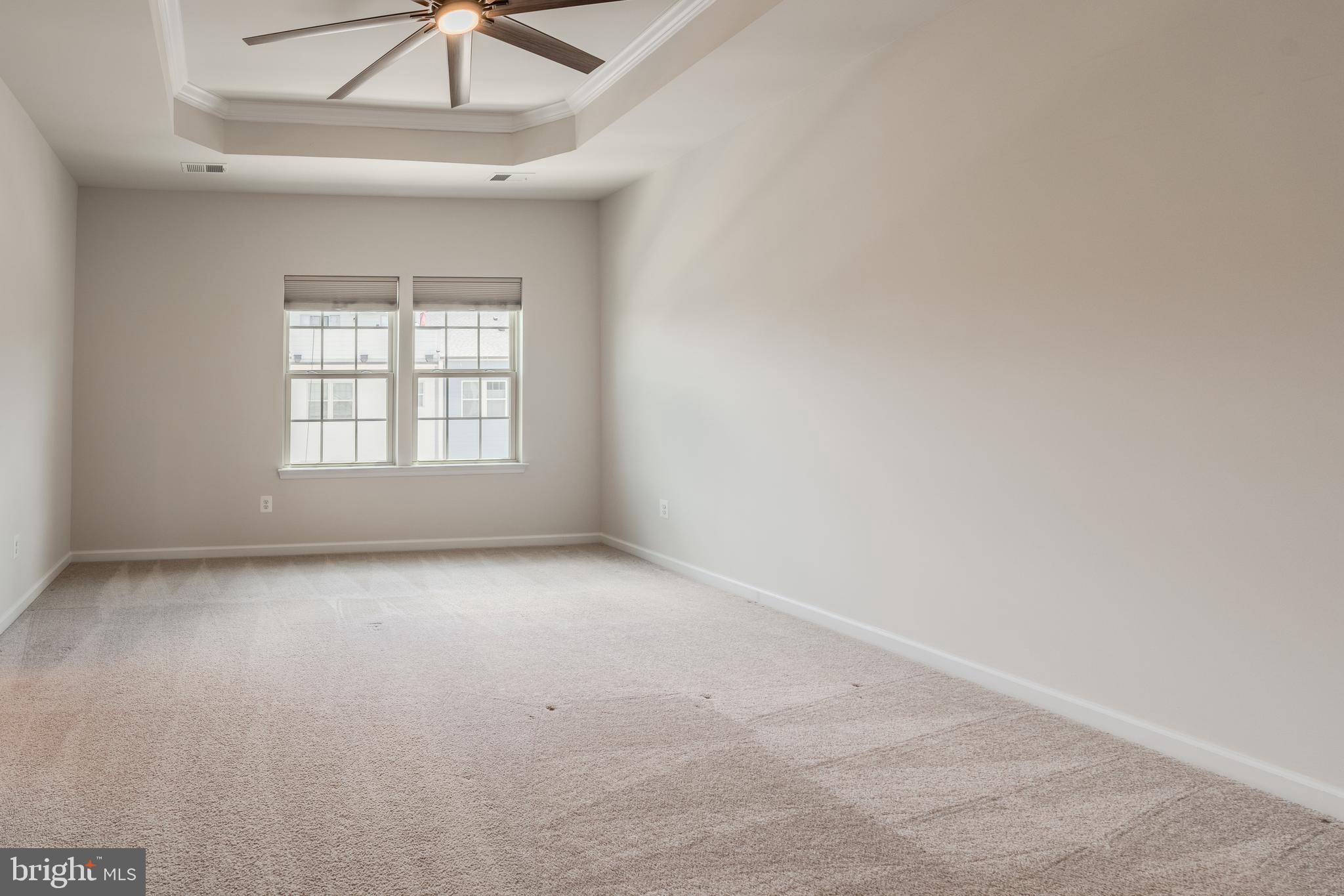 18191 Red Mulberry Road Dumfries, VA 22026 - Photo 18 of 42 an empty room with a chandelier fan and windows