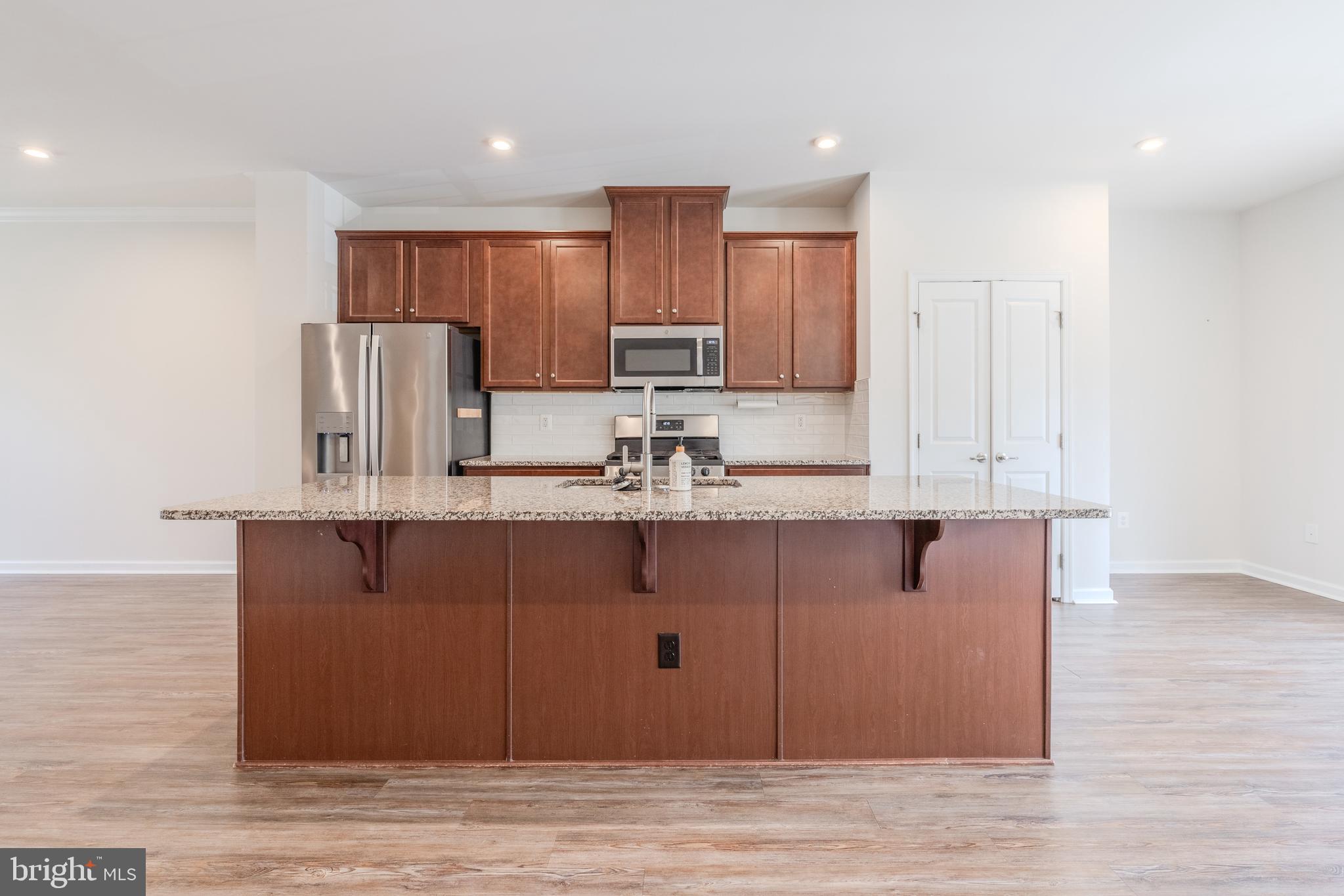 18191 Red Mulberry Road Dumfries, VA 22026 - Photo 2 of 42 a kitchen with kitchen island cabinets and wooden floor