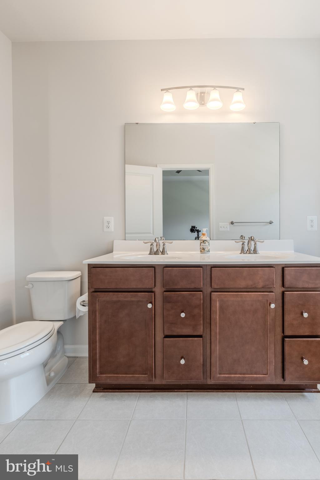 18191 Red Mulberry Road Dumfries, VA 22026 - Photo 23 of 42 a bathroom with a toilet a double vanity sink and a mirror
