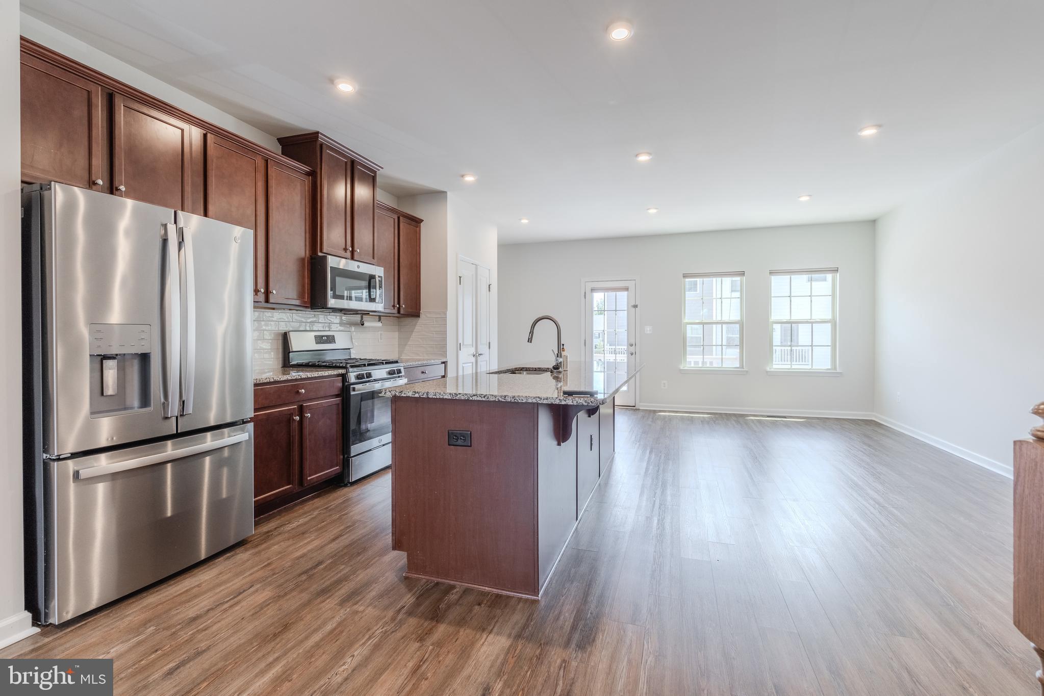 18191 Red Mulberry Road Dumfries, VA 22026 - Photo 3 of 42 a kitchen with stainless steel appliances granite countertop a refrigerator a sink dishwasher a stove and white countertops with wooden floor