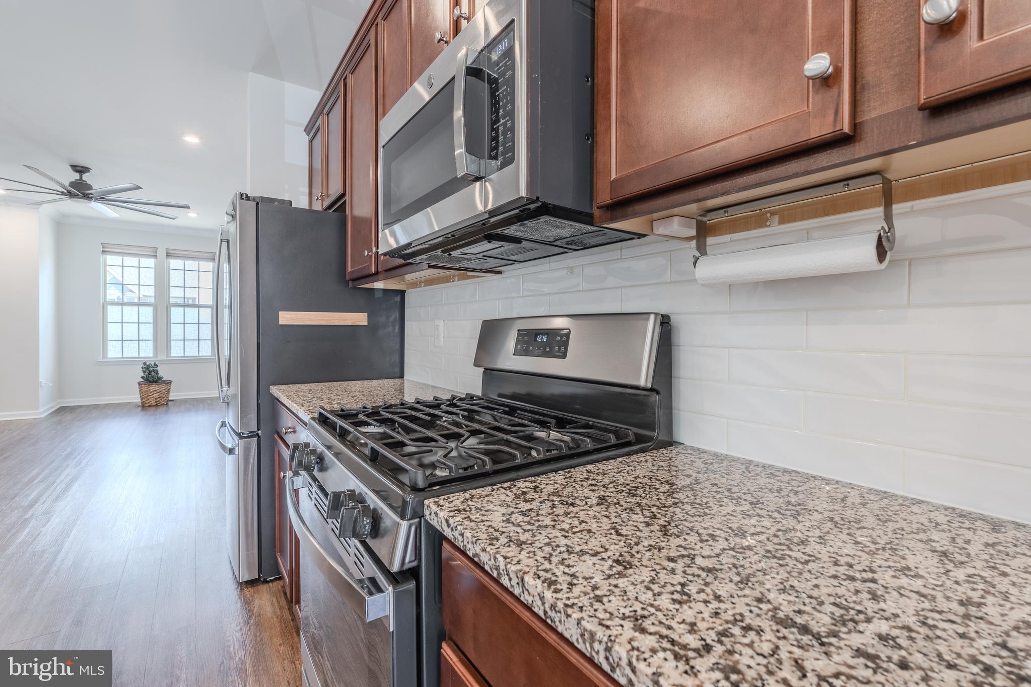 18191 Red Mulberry Road Dumfries, VA 22026 - Photo 5 of 42 a kitchen with stainless steel appliances granite countertop a stove a sink and a microwave