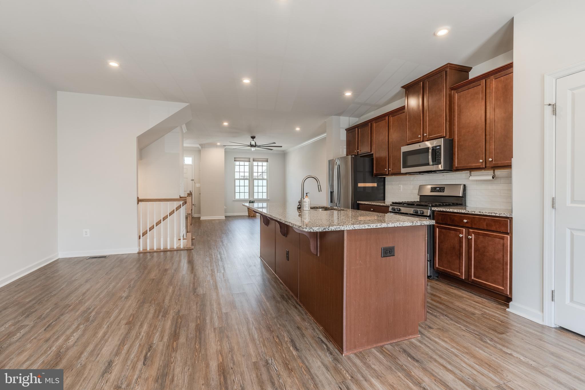 18191 Red Mulberry Road Dumfries, VA 22026 - Photo 7 of 42 a kitchen with stainless steel appliances granite countertop a stove a sink and a refrigerator