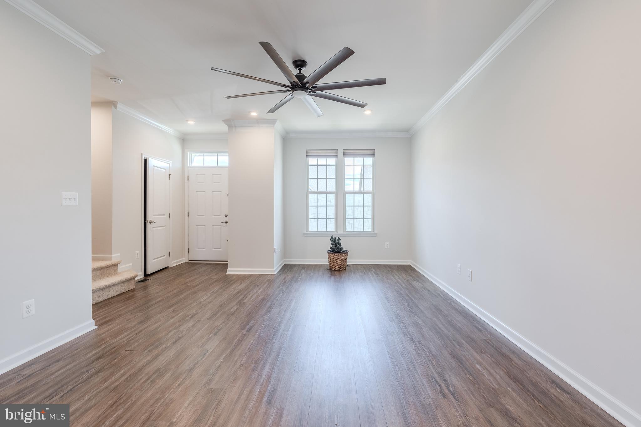 18191 Red Mulberry Road Dumfries, VA 22026 - Photo 9 of 42 an empty room with wooden floor fan and windows