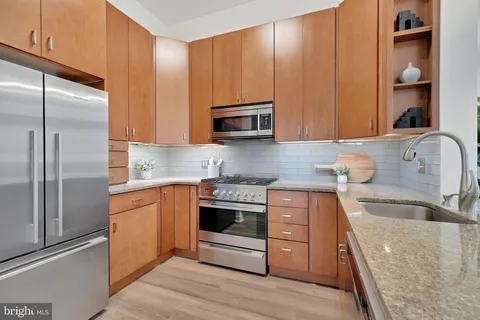 a kitchen with stainless steel appliances granite countertop a stove a sink and a microwave