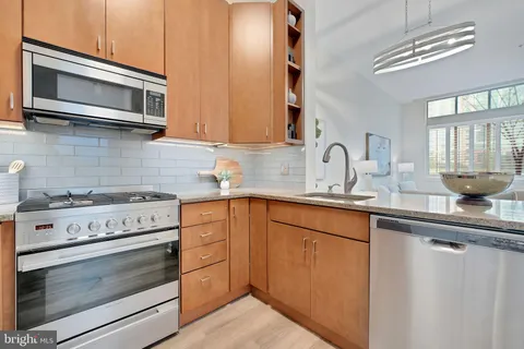 a kitchen with stainless steel appliances granite countertop a stove microwave and sink
