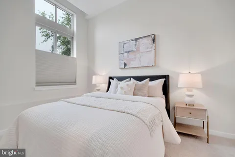a large bed sitting in a bedroom next to a window