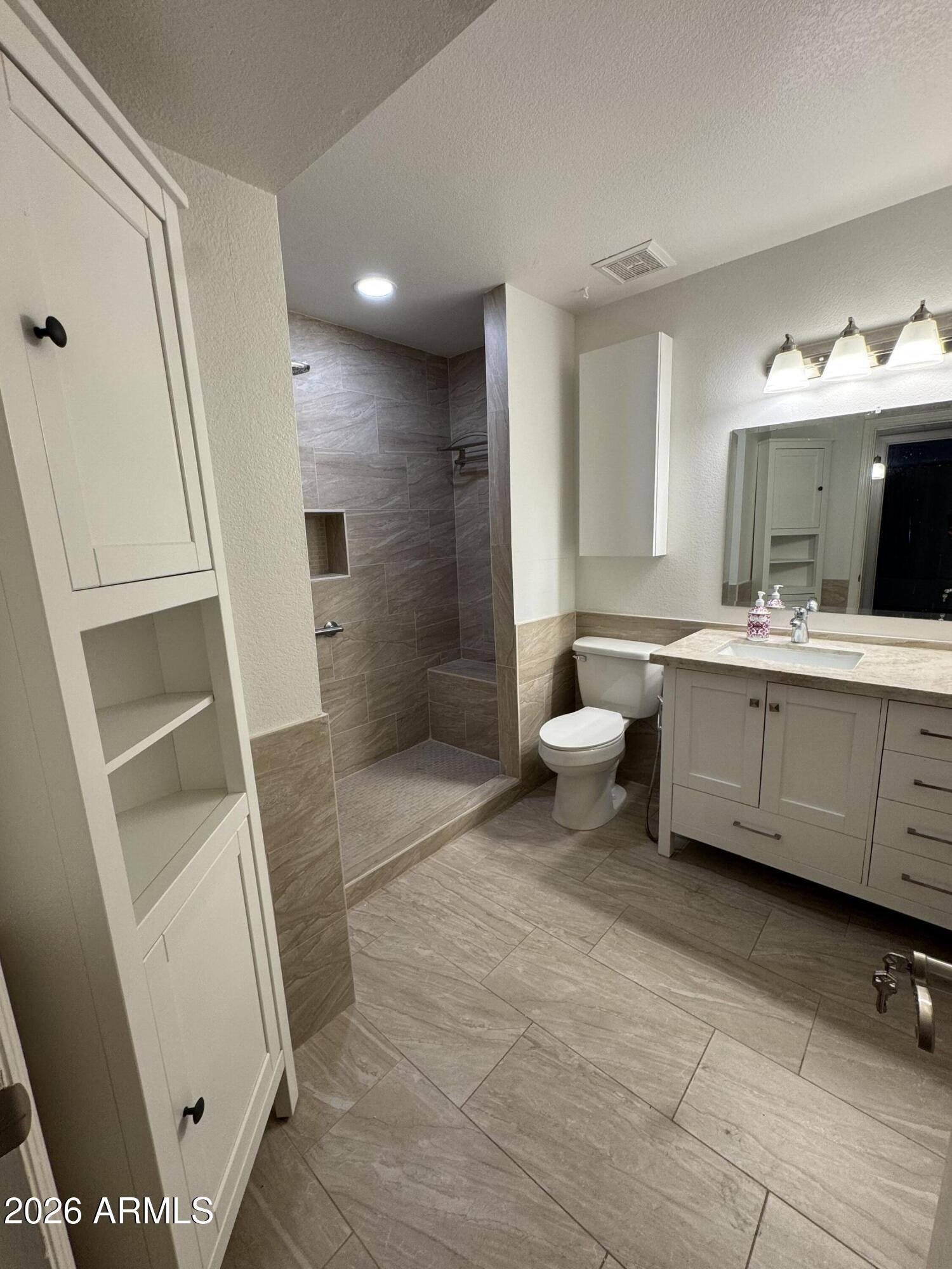 1645 West Baseline Road, Unit 1187 Mesa, AZ 85202 - Photo 13 of 16 a bathroom with a double vanity sink a mirror and a shower