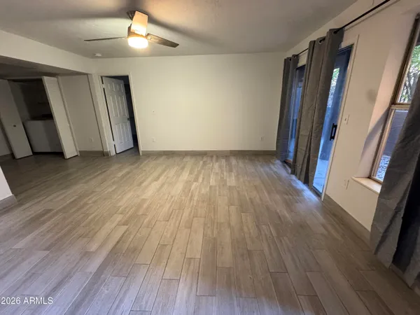 an empty room with wooden floor and staircase