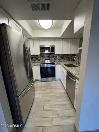 a kitchen with stainless steel appliances granite countertop a stove a refrigerator and a stove
